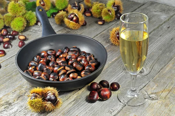 Roasted chestnuts with glass of white wine — Stock Photo, Image