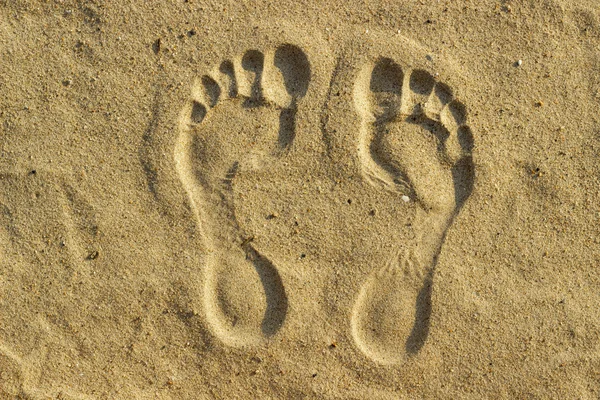 imprint of man\'s foot on the sand on the beach