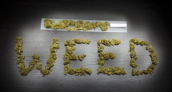 Ordet ogräs skriven med torkade cannabisplantan — Stockfoto