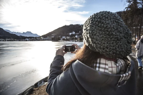 Woman takes a picture of a frozen lake — Stock Photo, Image