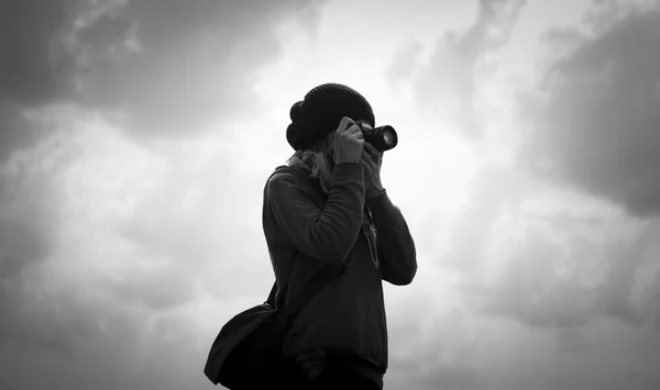 Silhouette eines Fotografen mit bewölktem Himmel Stockbild