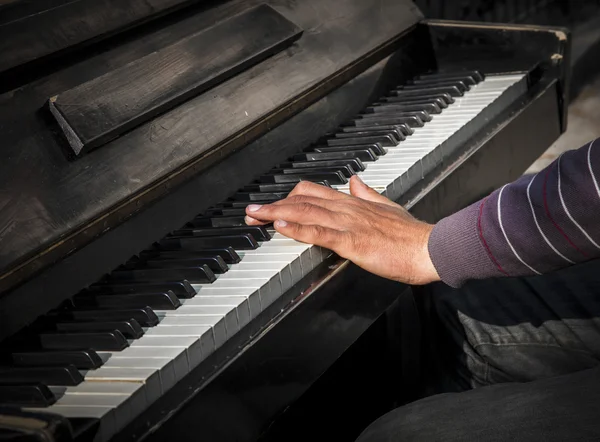 Mains d'homme jouant un vieux piano — Photo