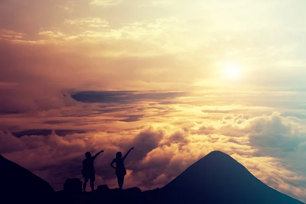 People standing on the top of the mountain above the clouds. — Stock Photo, Image