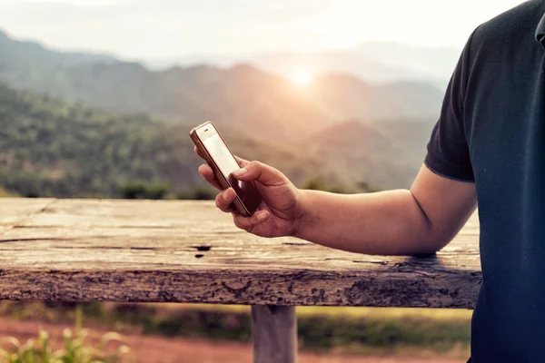 Manzara backgro ile mobil akıllı telefon kullanan adam, yakın çekim