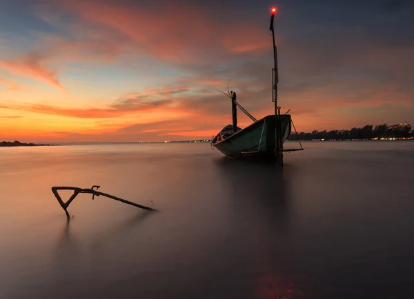 Barco de pesca na praia durante o pôr do sol — Fotografia de Stock