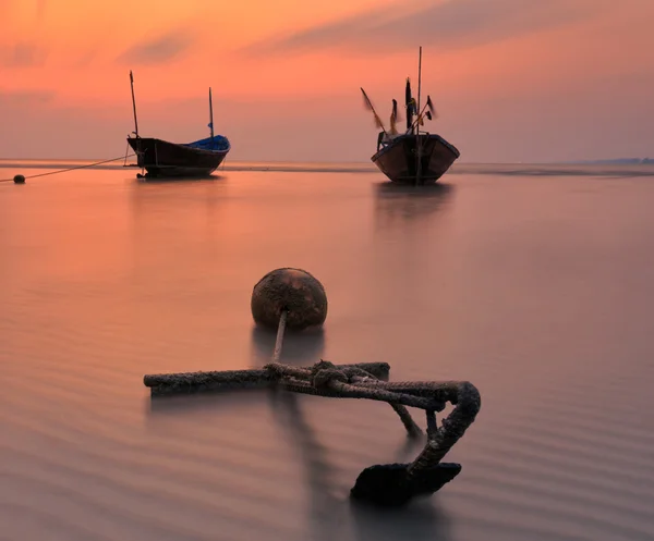 Barco de pesca na praia durante o pôr do sol — Fotografia de Stock