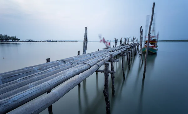 Bambusbrücke und bewegtes Fischerboot mit Langzeitbelichtungstechnologie — Stockfoto