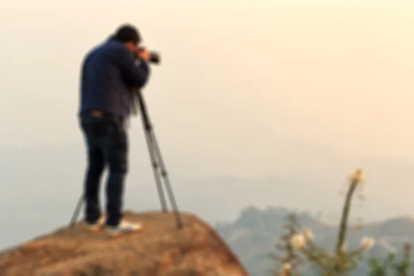 Fotógrafo desfocado atirando no pico da montanha — Fotografia de Stock