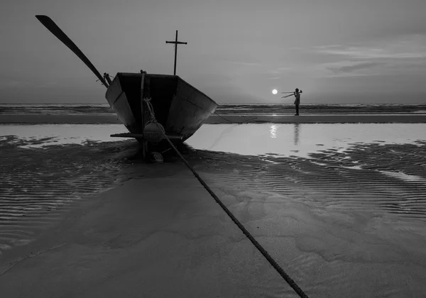 黒と白で日没時にビーチで釣りボート — ストック写真