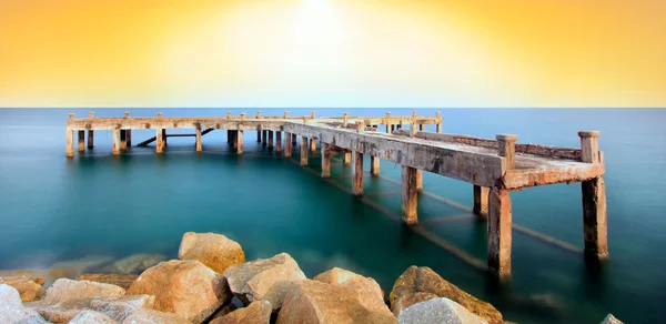 Güzel bir gün doğumu ile deniz üzerinde eski köprü, Rayong