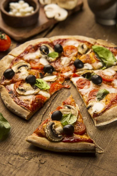 Pizza med mozzarellaost på ett träbord — Stockfoto