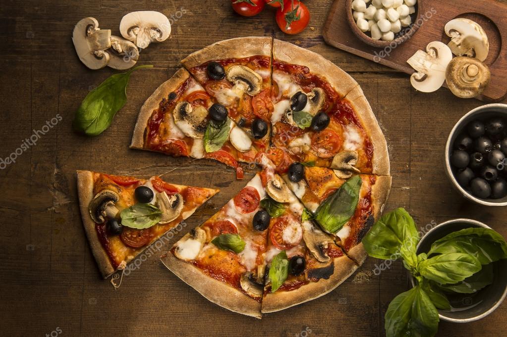 Pizza with mozzarella cheese on a wooden table Stock Photo by ©ekizv