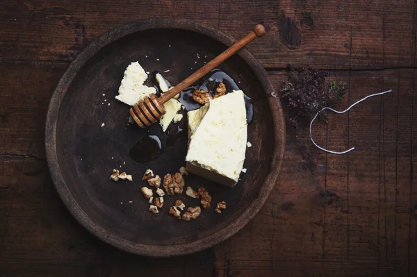 Queso de oveja con miel y nueces sobre una vieja mesa de madera —  Fotos de Stock