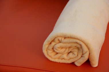 Turuncu arka planda turuncu banyo Havlu katlanmış.