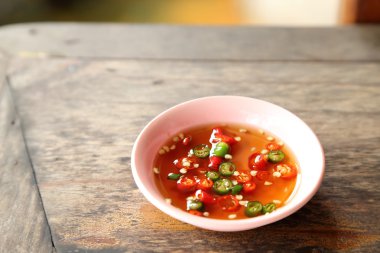 Ahşap masa küçük bardakta balık soslu biber.