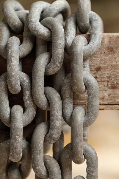 Pattern of thick rusty chain hang on wooden rail. — Stock Photo, Image