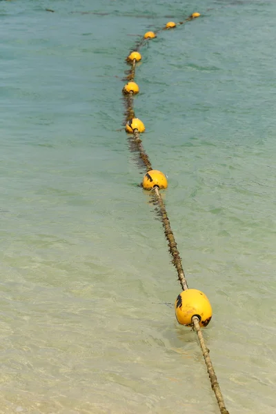 Line of yellow buoys on the rope floating in the sea. — Stock Photo, Image