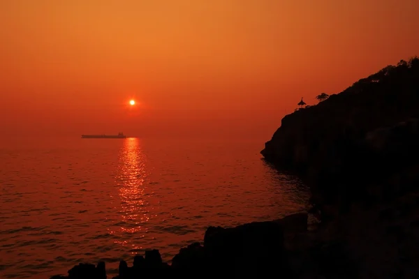 Puesta de sol sobre el mar con el barco de silueta y las islas . — Foto de Stock