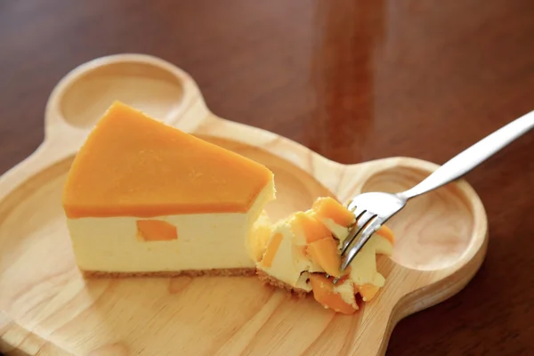 Pieces of Mango cheesecake on wooden plate. — Stock Photo, Image