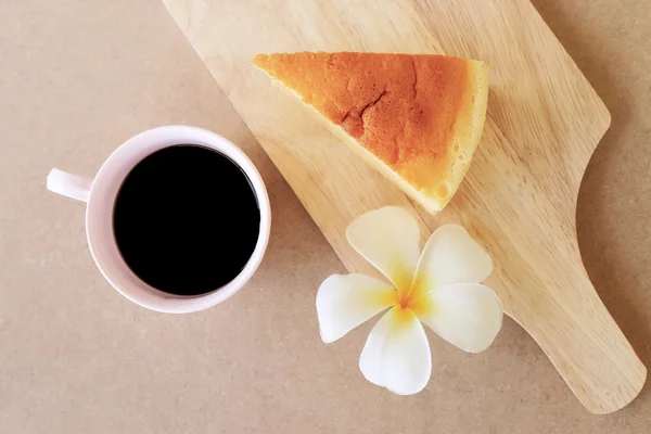 Pieces of Japanese style Cheesecake and cup of black coffee, top view on wooden plate. Royalty Free Stock Images