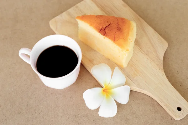 Piezas de estilo japonés Cheesecake y taza de café negro en plato de madera . —  Fotos de Stock