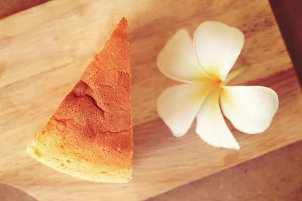 Pieces of Japanese style Cheesecake, top view on wooden plate. Vintage toned image of sweet recipe. — Stock Photo, Image