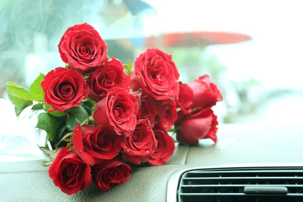 Ramo de rosas rojas en la consola del coche Fotos de stock