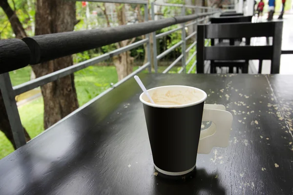Café caliente en taza de papel sobre mesa de madera —  Fotos de Stock