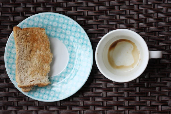 Empty coffee cup and half toast — Stock Photo, Image