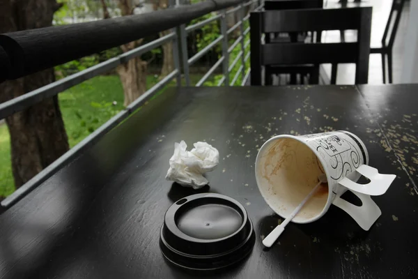 Empty dirty coffee cup as garbage on wooden table — Stock Photo, Image