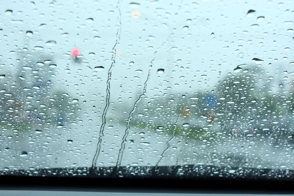 Vägutsikt genom bilfönstret med regndroppar — Stockfoto