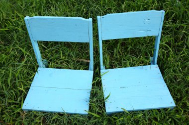 Yeşil çimenlerin üzerinde mavi ahşap sandalye