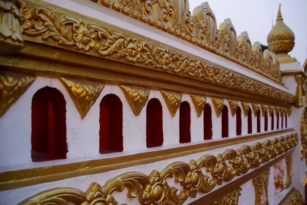 Белая стена с золотой штукатуркой в тайском храме — стоковое фото