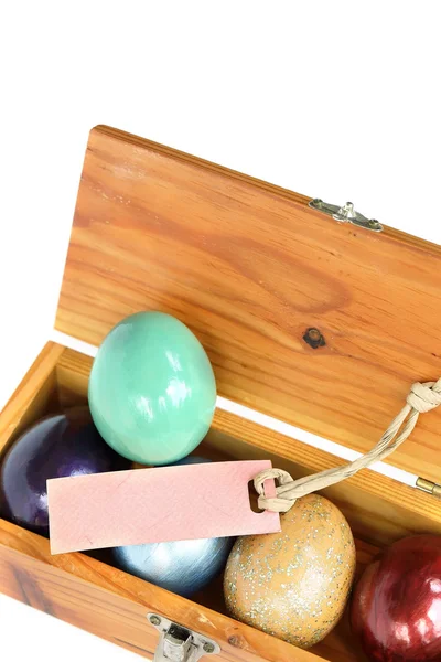 Uova di Pasqua colorate in scatola di legno su sfondo bianco con carta — Foto Stock