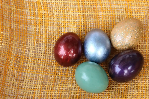 Colorful easter eggs on bamboo weave sheet background. — Stock Photo, Image