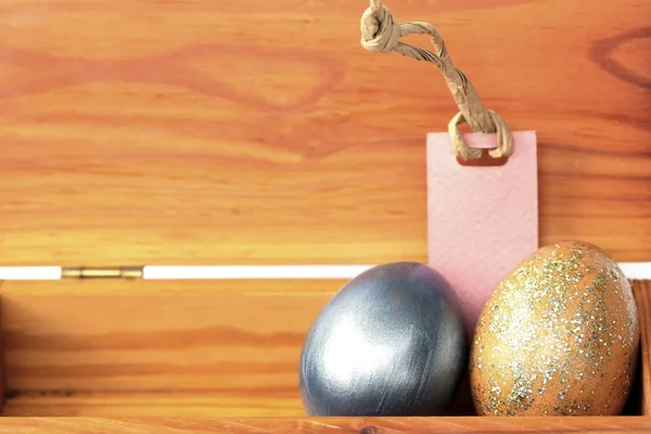 Colorful easter egg in wood box with paper tag. — Stock Photo, Image