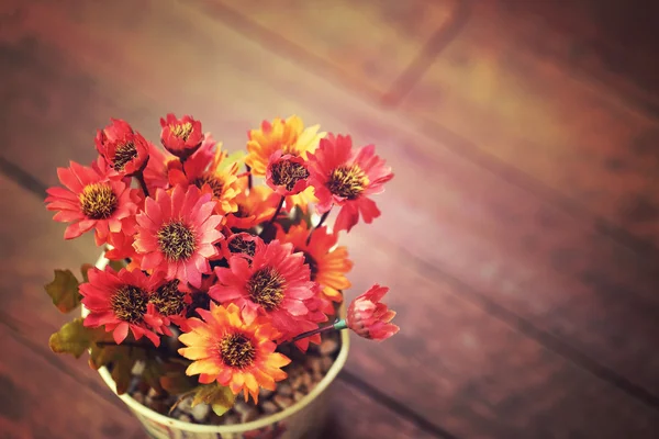 Flores artificiales en maceta pequeña sobre mesa de madera con espacio vacío —  Fotos de Stock