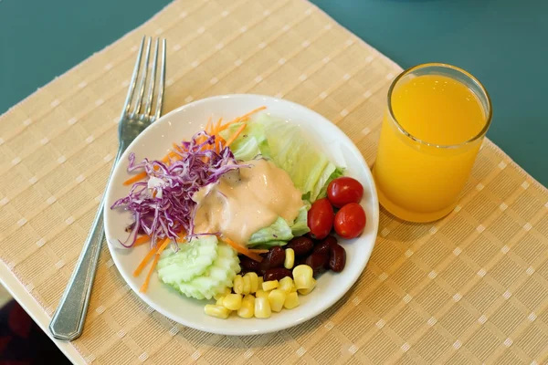 Gesundes Frühstücksset, frischer Gemüsesalat und Orangensaft. — Stockfoto