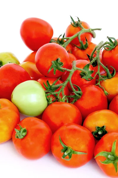 Grupo de tomates rojos con un verde sobre fondo blanco . — Foto de Stock