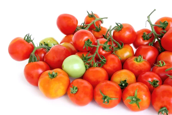 Grupo de tomates rojos con un verde sobre fondo blanco . — Foto de Stock