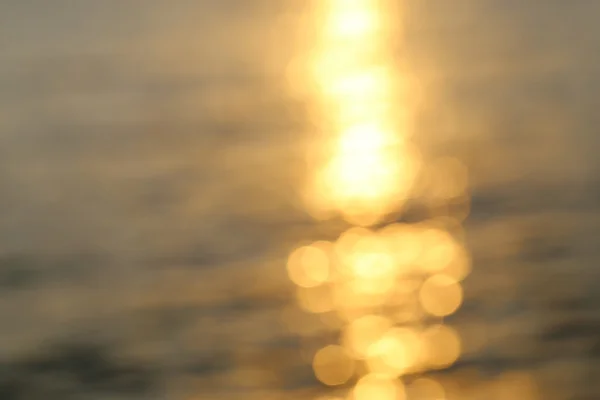 Resumen de la luz solar dorada bokeh sobre fondo azul de agua de mar . —  Fotos de Stock