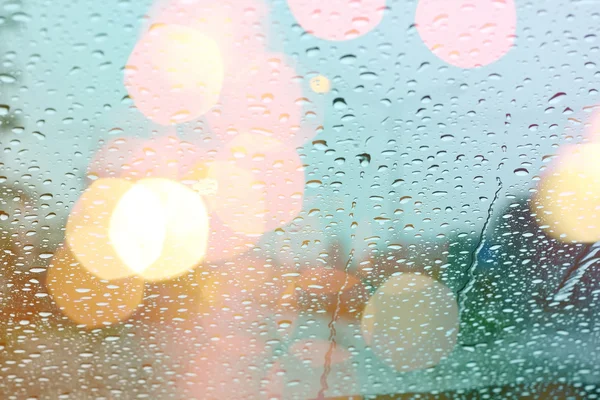 Chuva cai na janela com luz bokeh, estação chuvosa bac abstrato — Fotografia de Stock