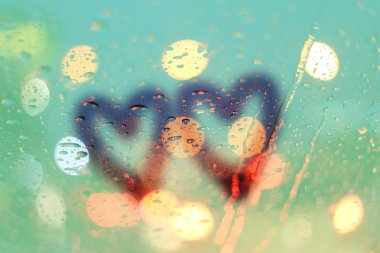 Damla yağmur ve ışık bokeh, penceresindeki iki kalp yazmak yağmur