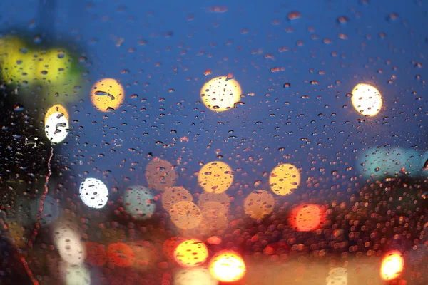 Chuva cai na janela com luz bokeh, estação chuvosa bac abstrato — Fotografia de Stock