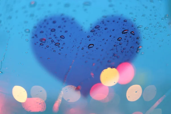 Regen druppels op venster met lichte bokeh op hart frame abstracte ba — Stockfoto