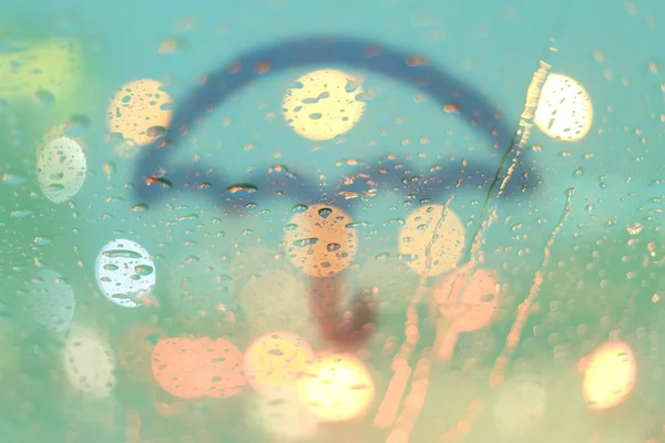 Gotas de chuva e guarda-chuva escrever na janela com bokeh luz, chuvoso — Fotografia de Stock