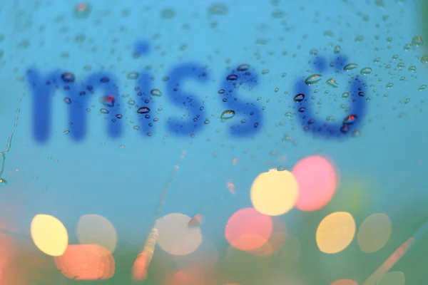 Gotas de chuva e coração borrado escrevem na janela com luz bokeh, r — Fotografia de Stock