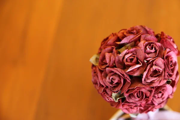 Artificial roses in small pot on wooden table. — Stock Photo, Image