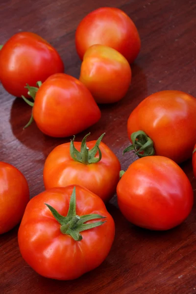 Grupo de tomates sobre fondo de madera . — Foto de Stock