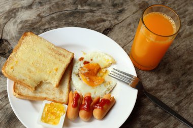 Ahşap masa üzerinde Amerikan kahvaltı seti.